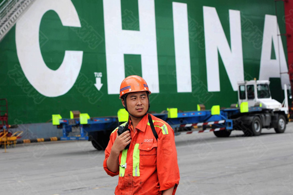 在中国山东省青岛市青岛港，一名码头工人在一艘集装箱船前工作贸易经济d.jpg